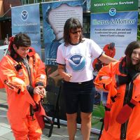 Kids trying on survival suits at the NOAA booth at Seattle Science EXPO Day.