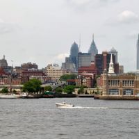 A small boat on the Delaware River with Philadelphia's skyline in the background