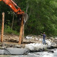 Crews place large wood material which will become engineered log jam habitat for