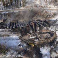 Smoldering train cars derailed from the railroad tracks in snowy West Virginia.