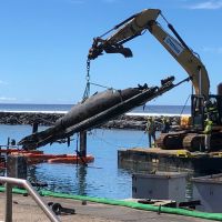 A crew from Global Diving and Salvage lift a burned and sunken vessel out of Lahaina Harbor on October 15, 2023. Image credit: NOAA/Ruth Yender