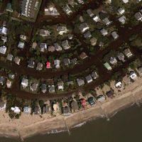 Aerial photo of coastline with houses.