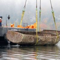 A derelict vessel being pulled out of the water.