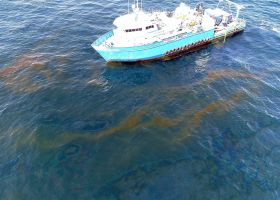 An aerial image of a vessel near spilled oil.
