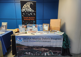 The NOAA Marine Debris Program table at the Summit, showcasing materials and outreach activities related to the prevention, research, and removal of marine debris. The table also included funding opportunity information from both the Marine Debris Program and National Sea Grant Office related to marine debris opportunities (Credit: NOAA).
