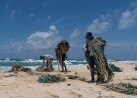 A small team removing ghost nets from the shoreline of Kamole (Laysan island) (Credit: Andrew Sullivan-Haskins, Papahānaumokuākea Marine Debris Project).