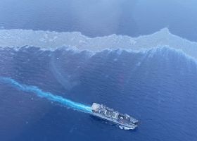 An aerial image of a boat near an oil sheen.