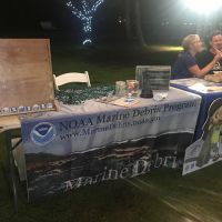 A table with a "Marine Debris Program" poster and a plinko board.