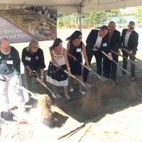 A group of people shoveling dirt.