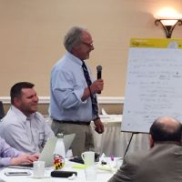 Man teaching class, looking at flip chart