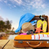 Suitcase with flip-flops, sunglasses, hat, etc.