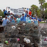 People posing with crab pots and debris.