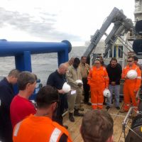 Group of people working on the deck of a boat.