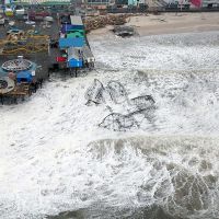 An aerial view of a roller coaster, wrecked, in the ocean.