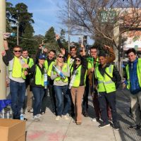 Group of people in matching green vests outdoors.