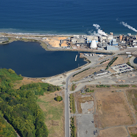 Aerial view of land, facility, and surrounding water. 